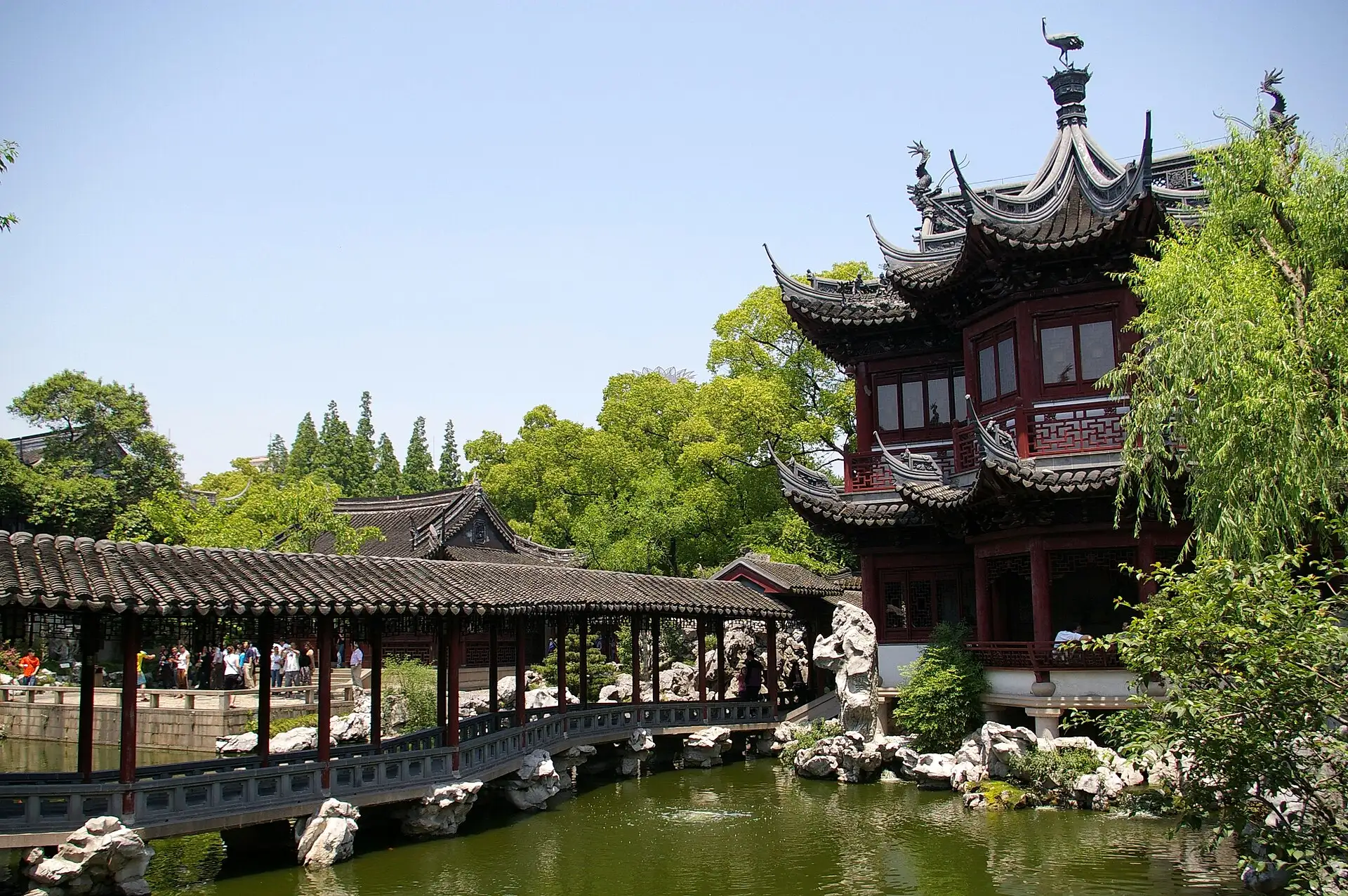 A covered corridor above a pond and a pavilion inside Yu Garden.