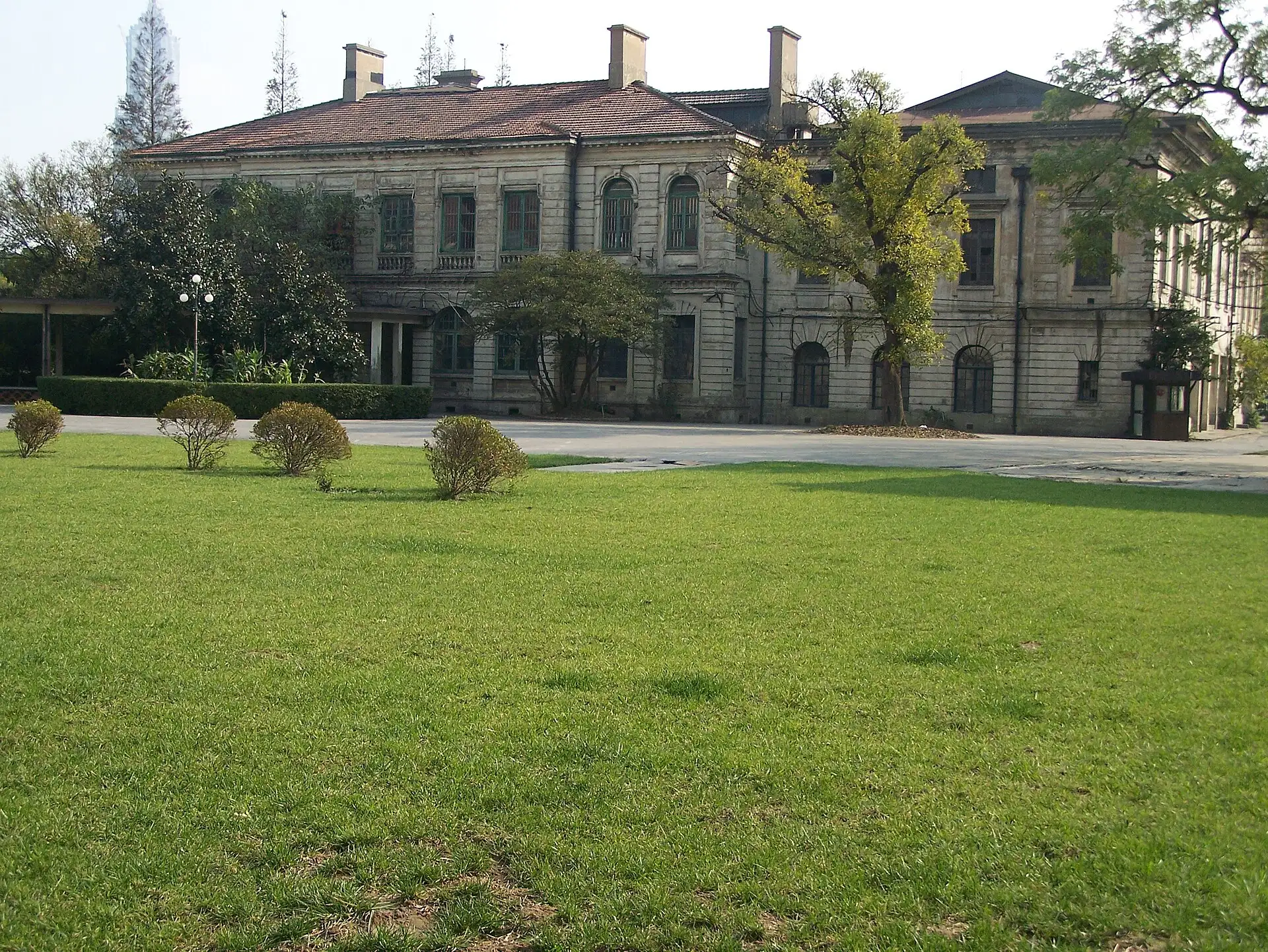 The former British Consulate, a two-storey brick building with arcaded verandas, behind a wide lawn.