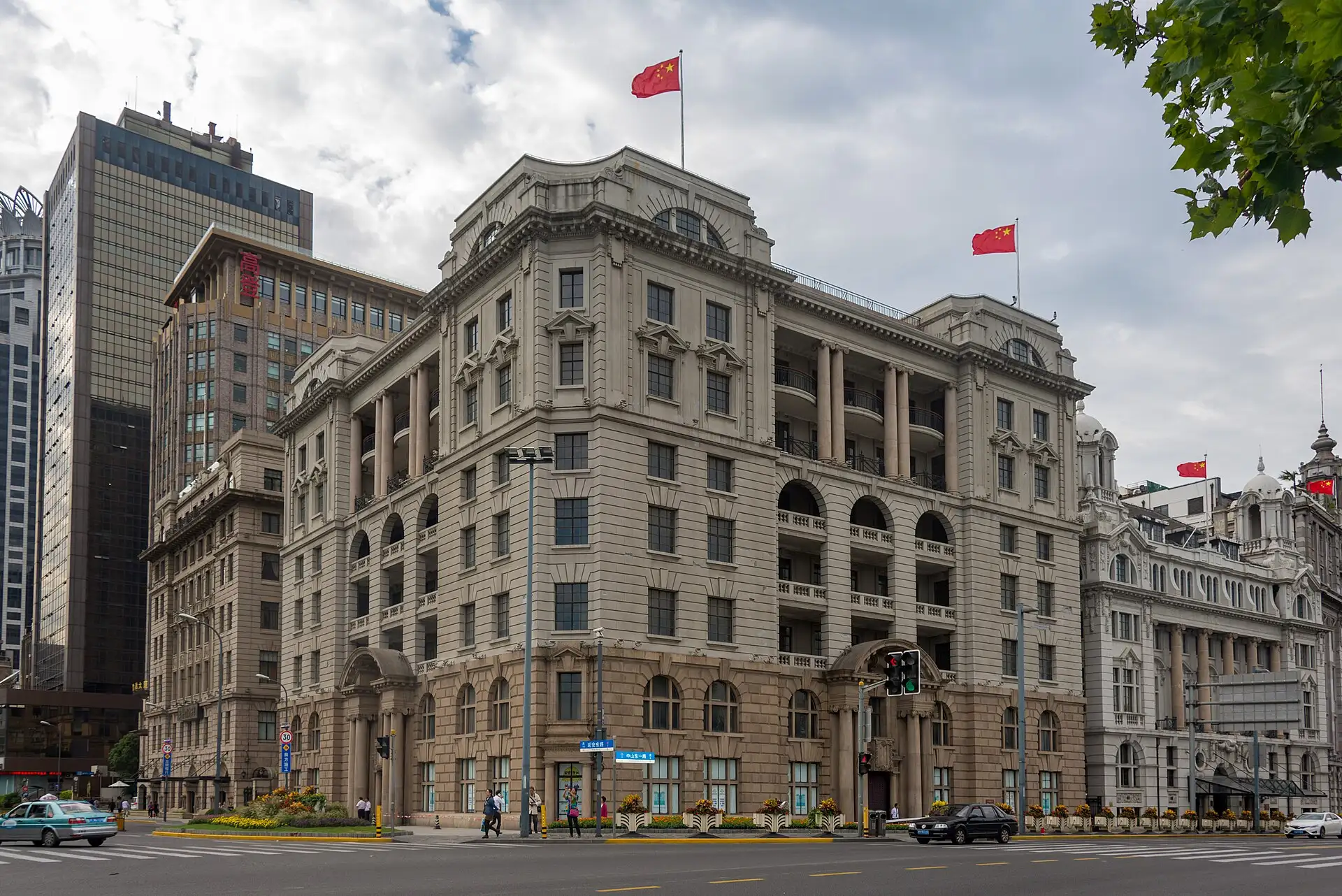 The Asia Building at Bund 1, a stone block with columns and a rounded corner.