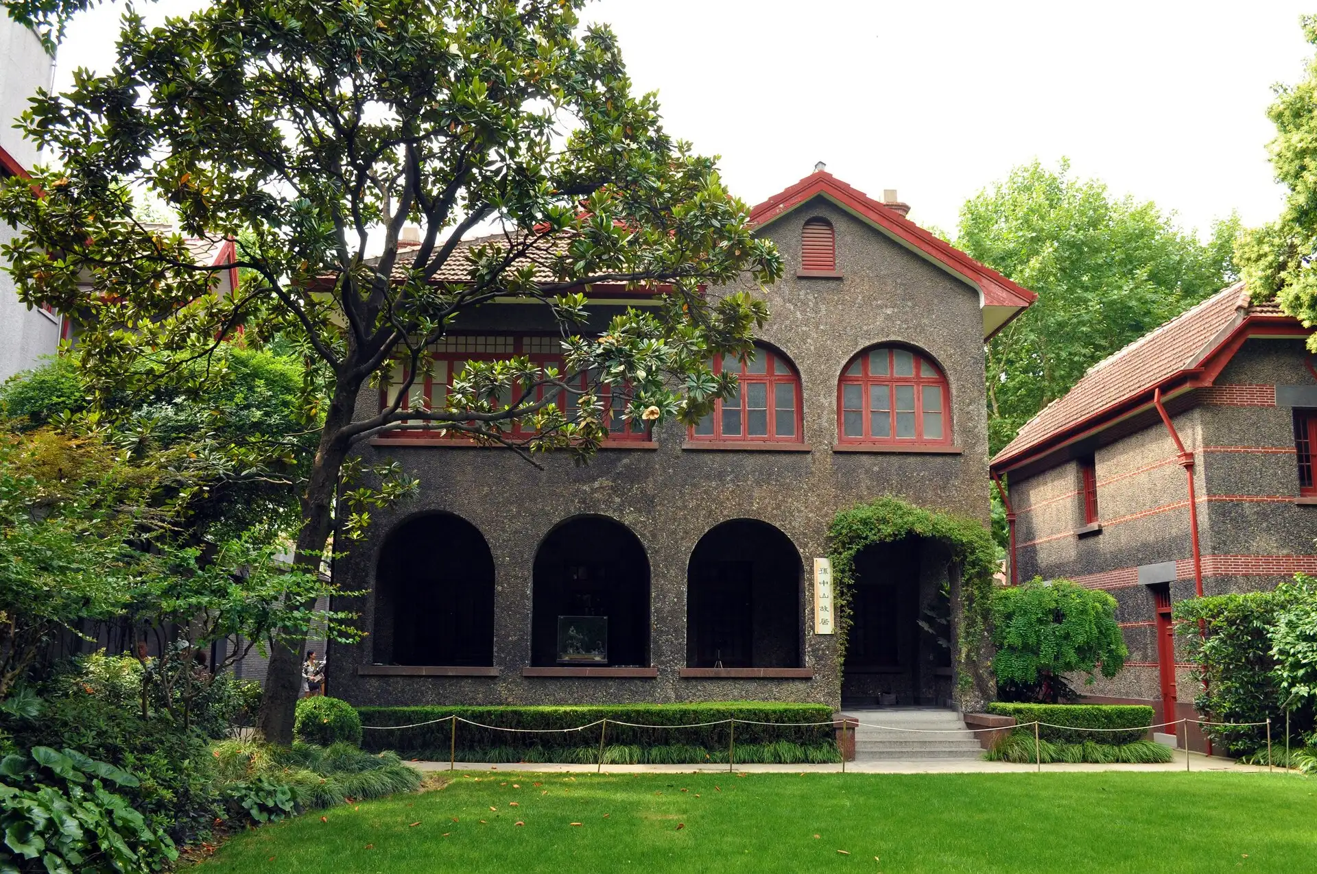 Sun Yat-sen's former residence, a grey-brick house with an arched veranda and a lawn in front.