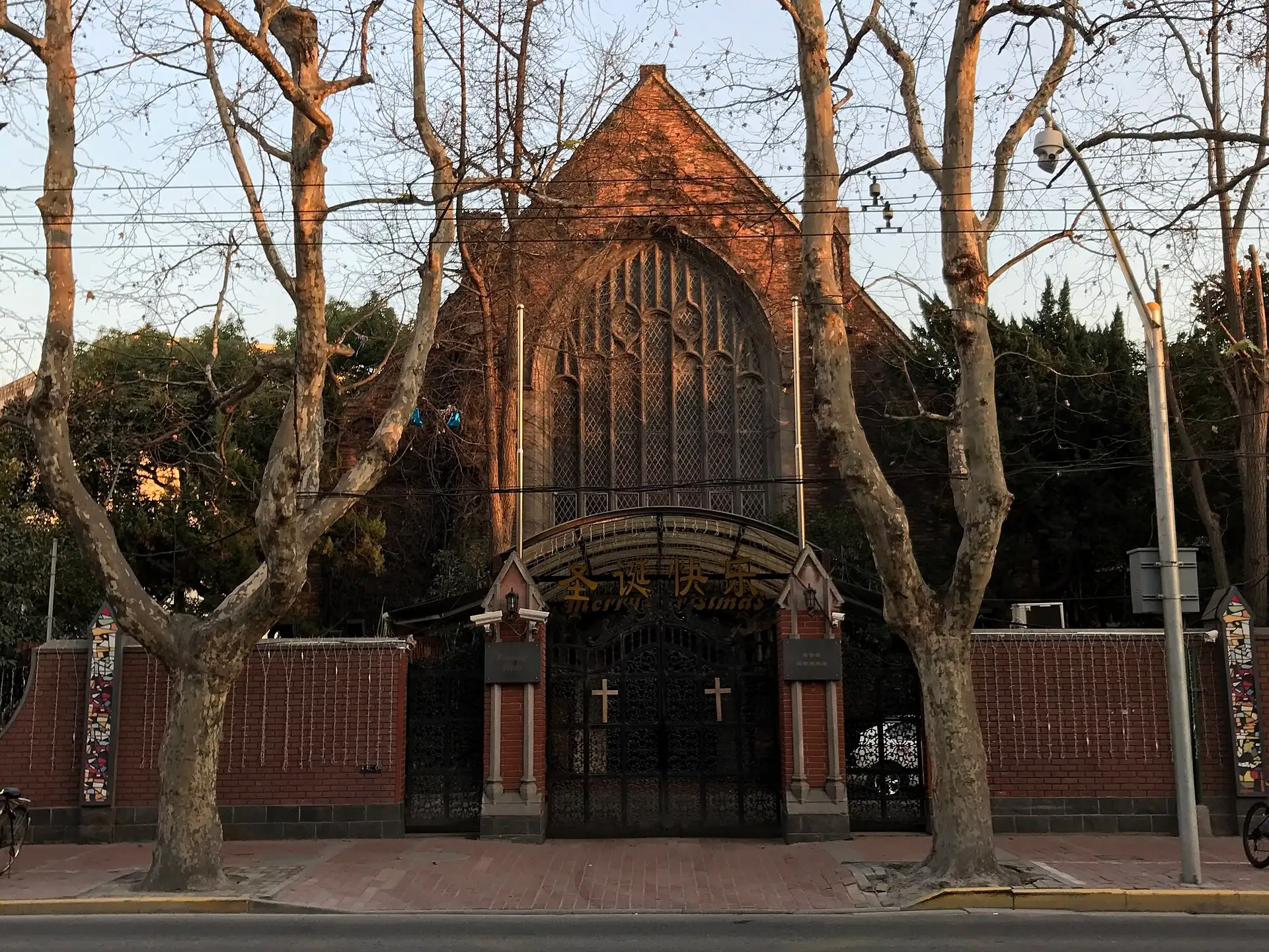 The Community Church, a red-brick gable with a tall pointed window, behind its gate.