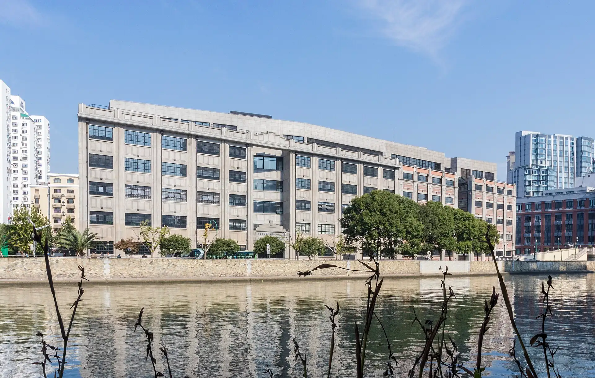 Sihang Warehouse, a long grey concrete block, seen across Suzhou Creek.