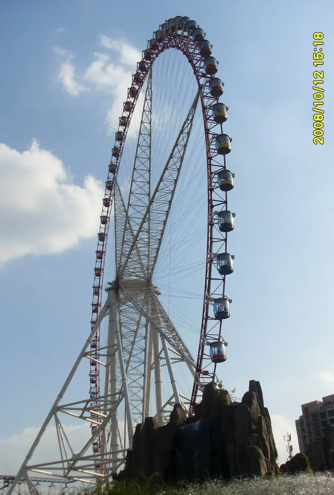 The tall Ferris wheel at Jinjiang Action Park against a blue sky.