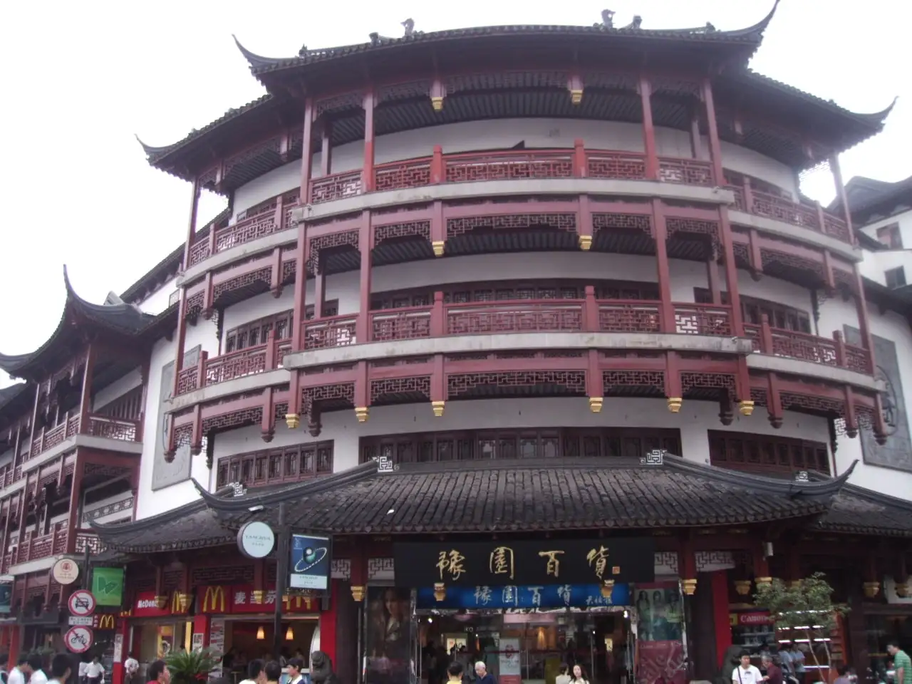 A multi-storey building at Yuyuan Bazaar, with red columns, curved tiled roofs and shops at street level.