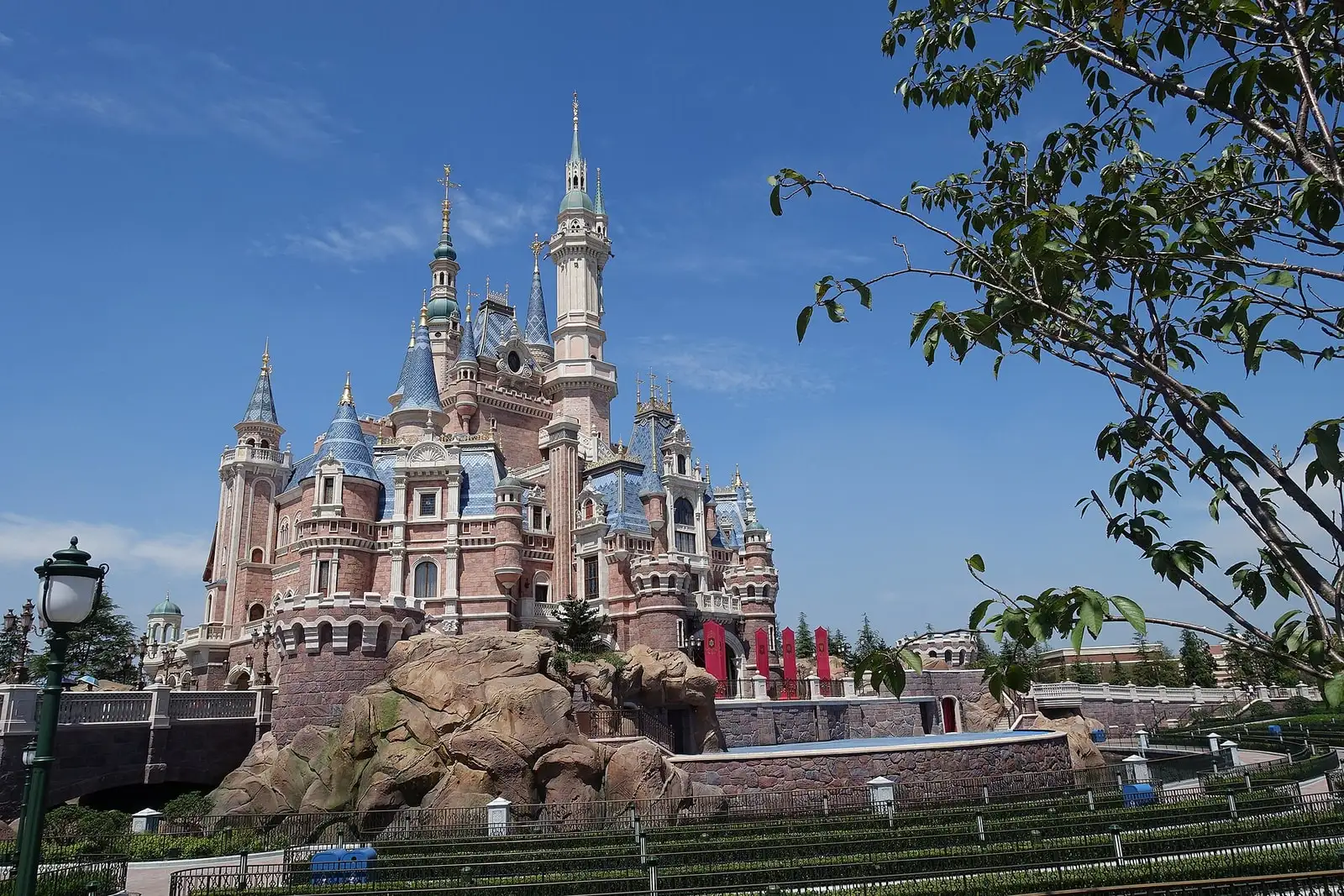 Shanghai Disneyland's Enchanted Storybook Castle, with many turrets above a landscaped moat.