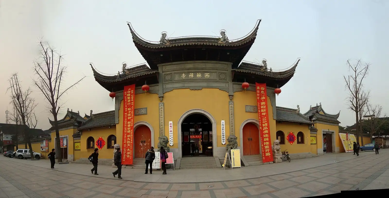 The yellow entrance gate of Xilin Temple, with arched red doorways and sweeping tiled eaves.