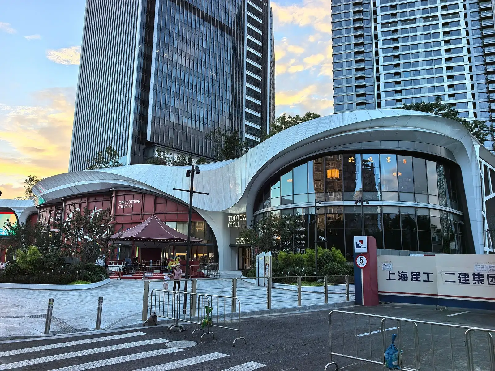 The curved entrance canopy and glass towers at Xinzhuang's TODTOWN shopping centre.