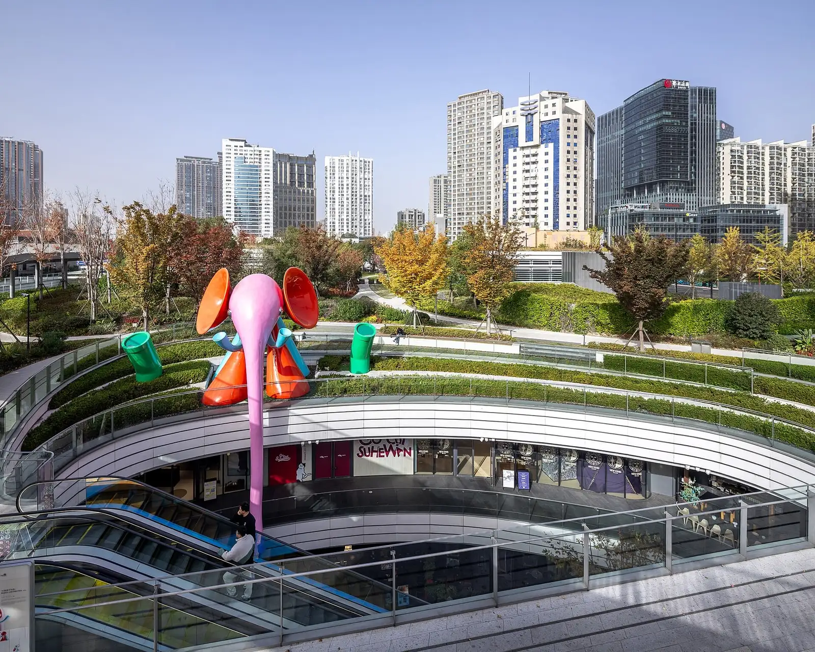 Landscaped terraces and curved walkways at Shanghai Suhe MixC World beside Suzhou Creek.