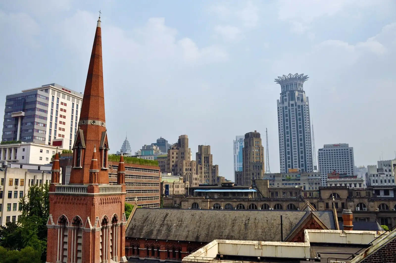Holy Trinity Cathedral in Shanghai, with its red-brick spire and long church roof against the city skyline.